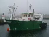 Green fishing vessel in port