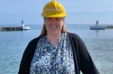 Woman in dress and black shirt in front of lighthouses