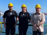 Group picture of two men and one woman in front of lighthouses