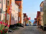 A streetview in Ærøskøbing with colored houses and a Danish flag